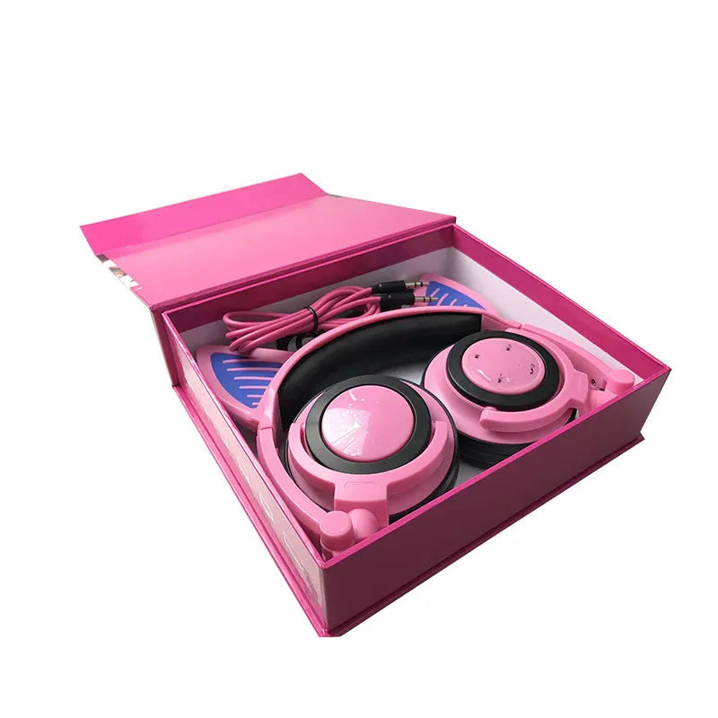 Pink headphones with microphone in a pink box on a white background
