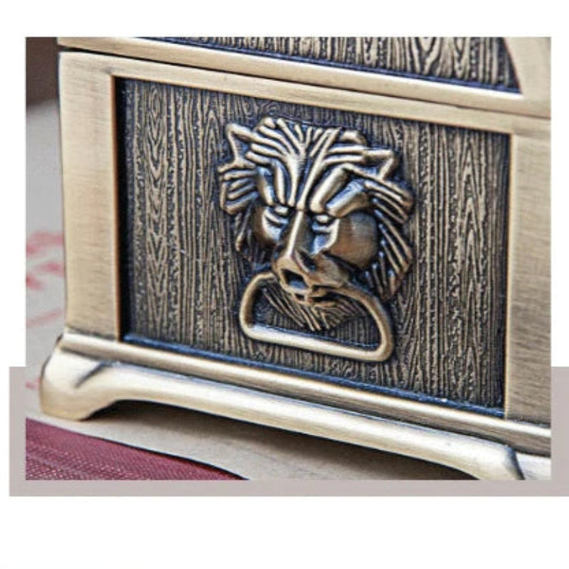 Decorative jewelry box with a lion emblem on a wooden surface