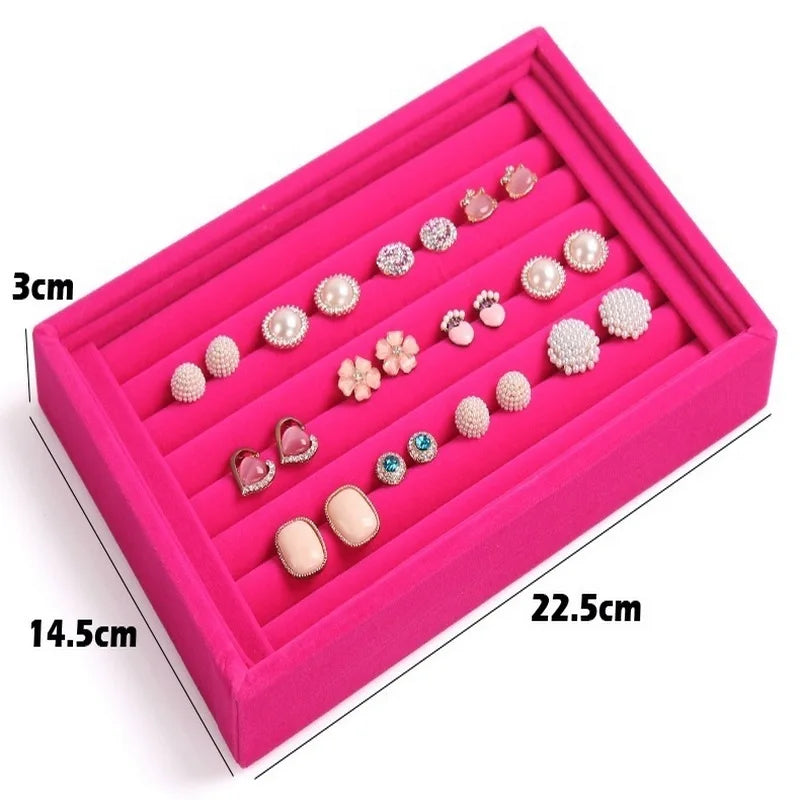 Pink jewelry box with various earrings inside, showing dimensions.