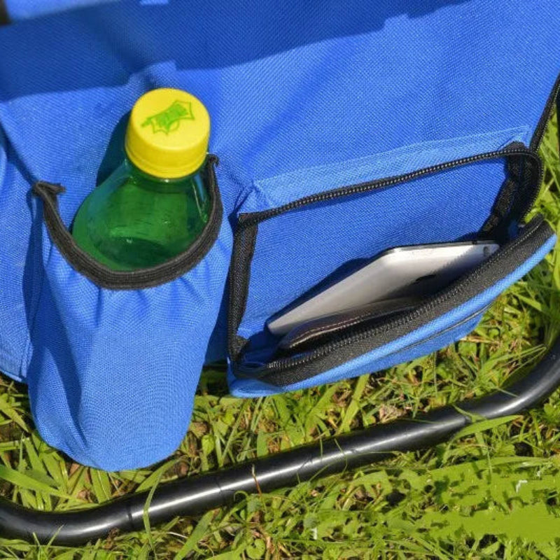 Blue folding chair with a bottle and phone in a pocket on grass