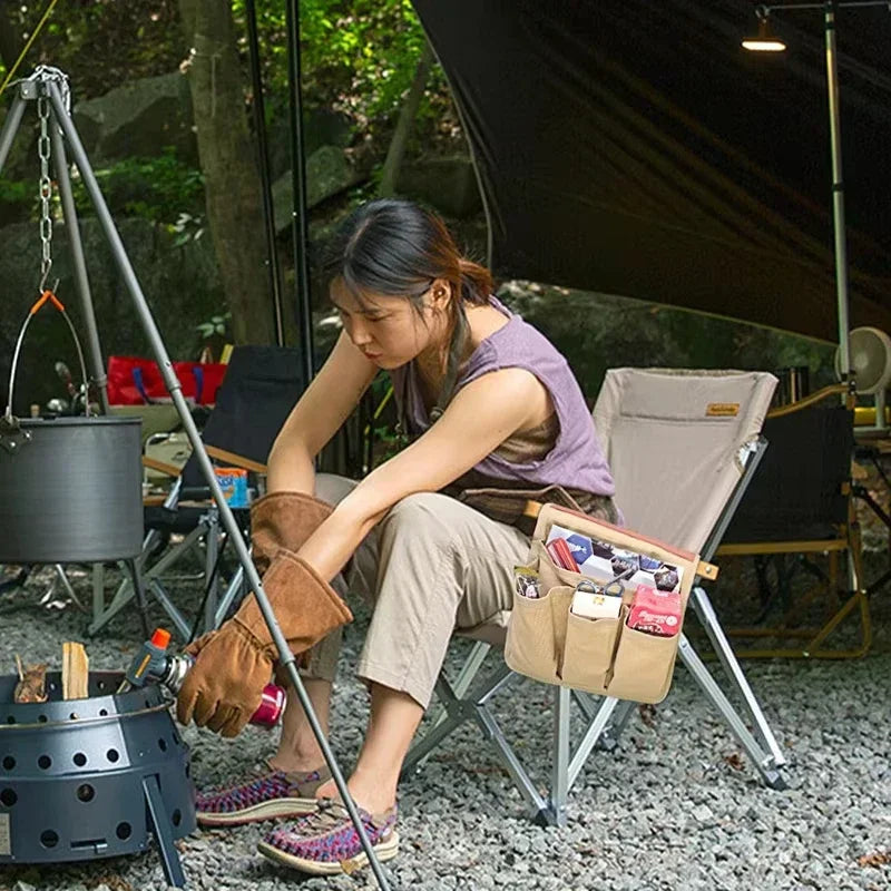 Woman sitting outdoors with camping gear, including a pot and tools bag.