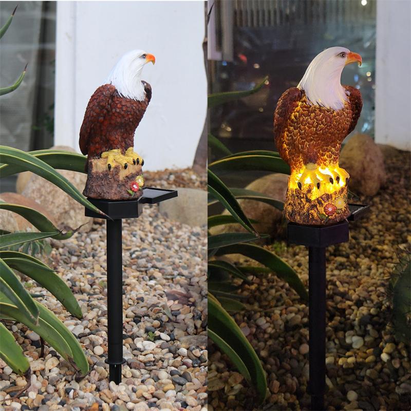 A solar-powered outdoor garden decor featuring a resin eagle statue that lights up at night.