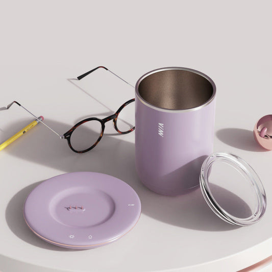 Purple tumbler with lid, glasses, and pencil on a light surface