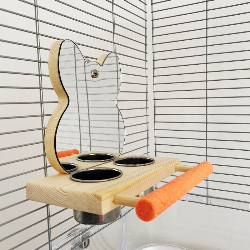 Wooden guitar-shaped shelf with three black bowls and orange foam rollers against a white tiled wall.