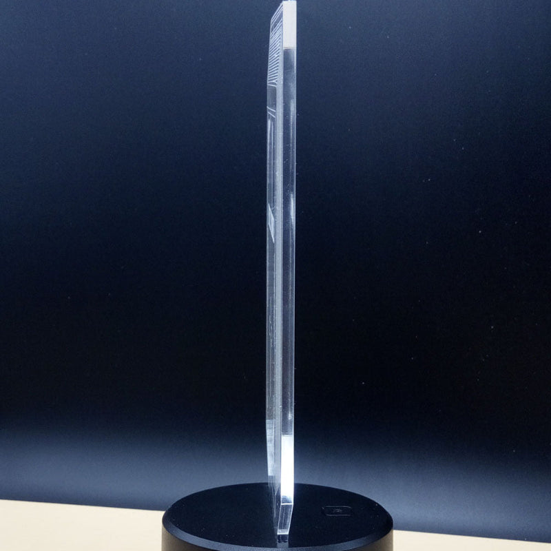 Clear crystal object on a black base against a dark blue background
