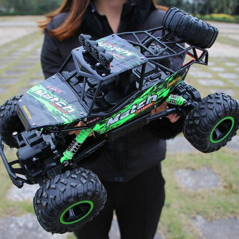 Person holding a large remote control monster truck outdoors