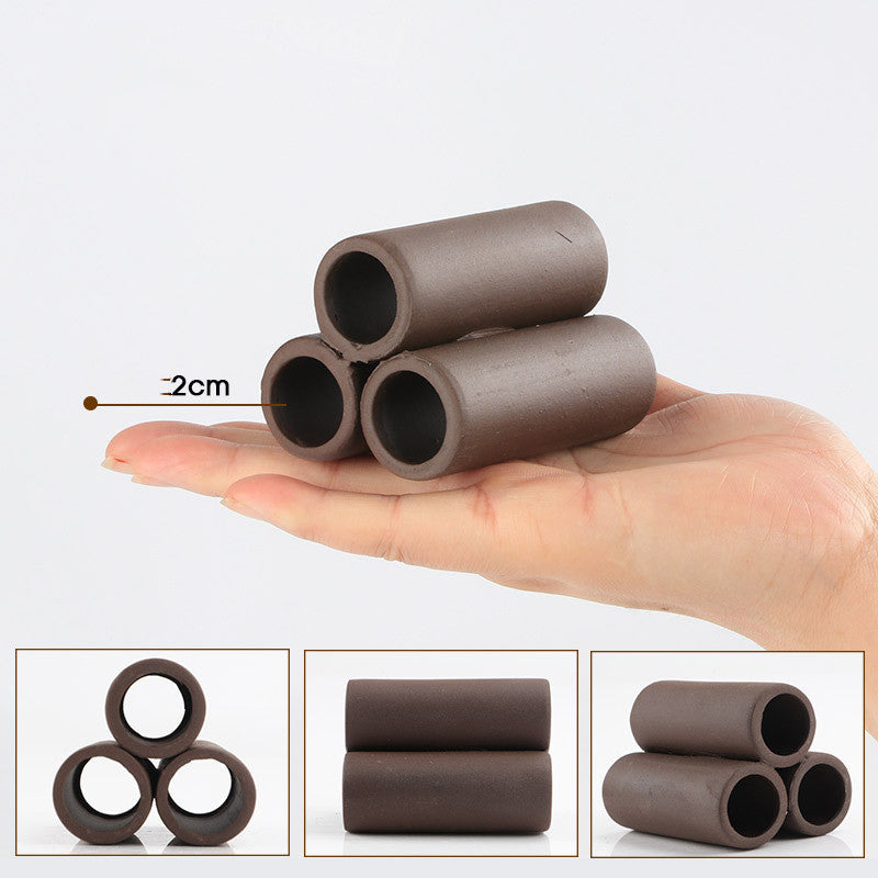Three small brown cylindrical objects held in a hand with a 2cm measurement label.
