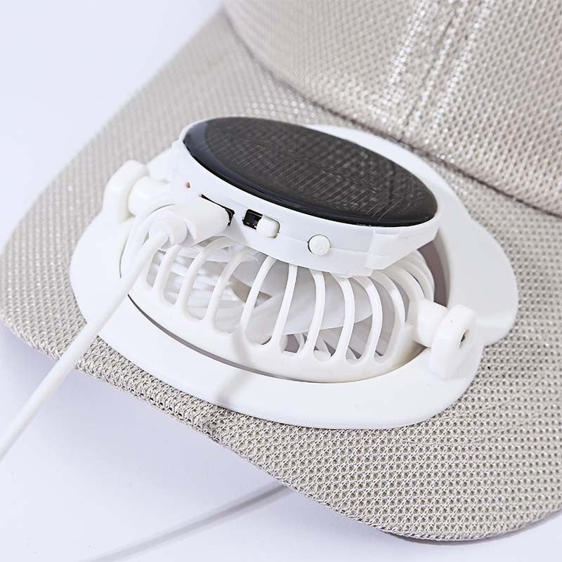 Small white fan with black top on a textured surface