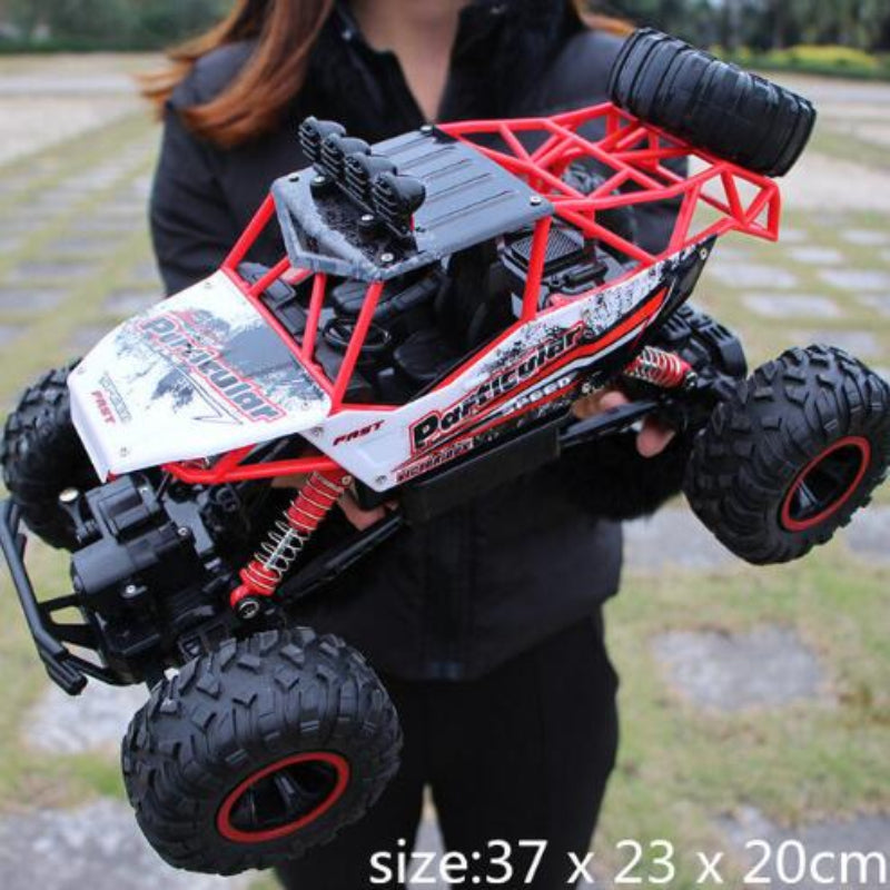Person holding a large remote control monster truck outdoors