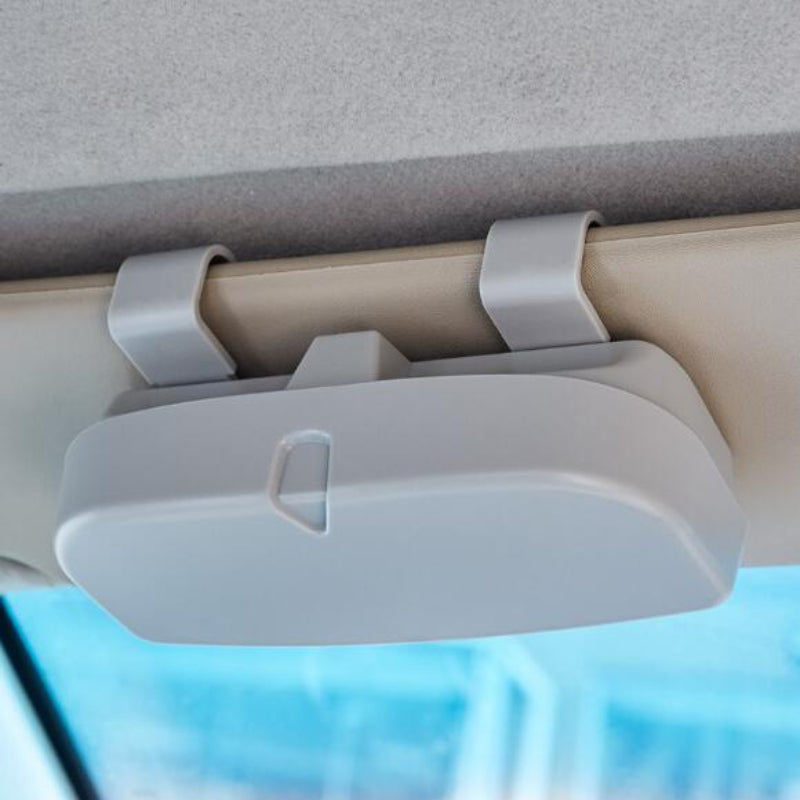 Car visor organizer attached to a car's sun visor with a blurred outdoor background
