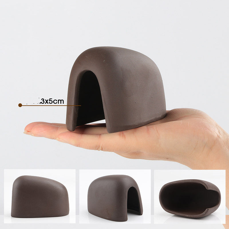 Small brown ceramic object held in a hand with measurements, displayed on a white background.