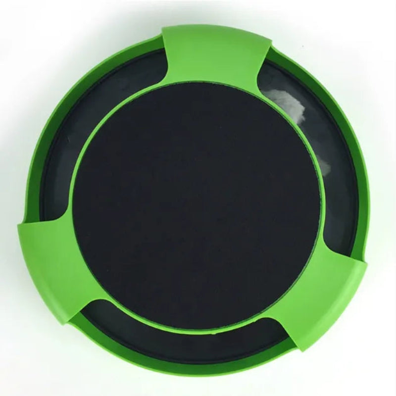 A circular green and black lid or cover, viewed from above, featuring a bright green outer rim with four tab-like extensions and a solid black center.