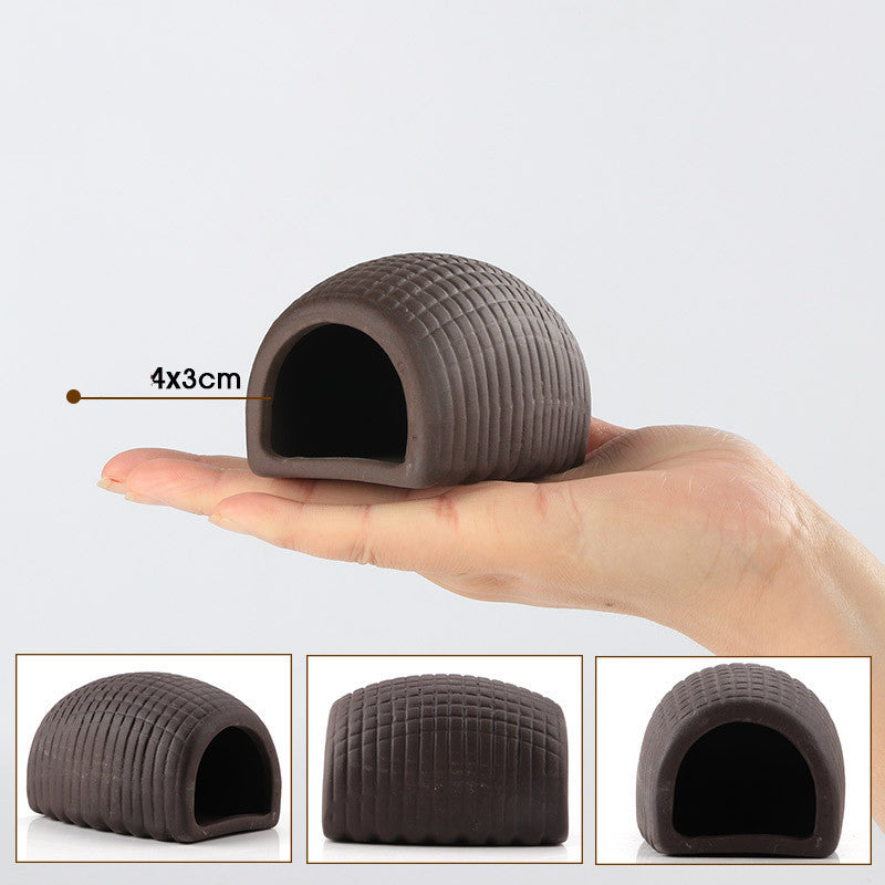 Small brown pet house held in a hand with measurements indicated, on a white background.