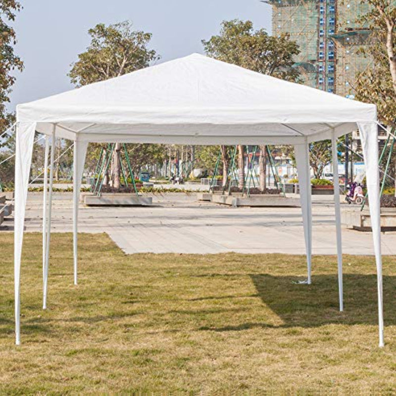White outdoor canopy tent set up on grass with trees and buildings in the background