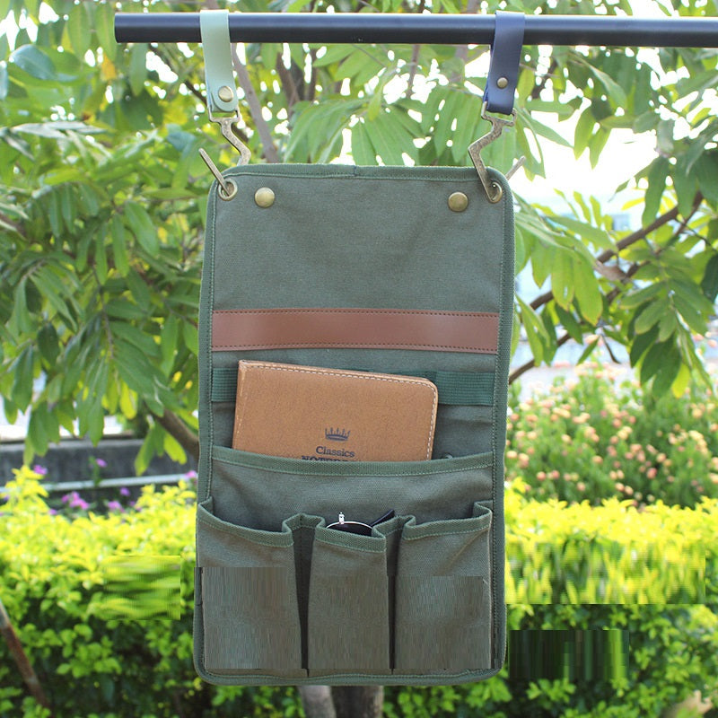 Green hanging organizer with pockets against a green outdoor background