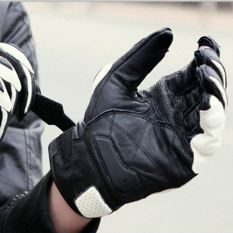 Black motorcycle glove with white accents on a blurred background