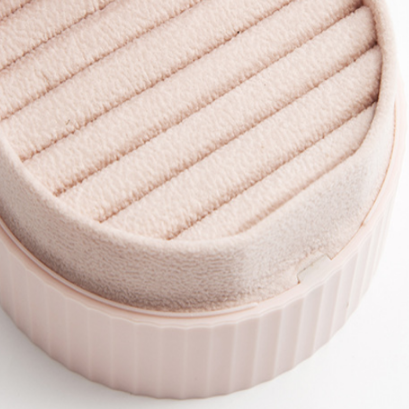Close-up of a textured pink cosmetic compact on a white background