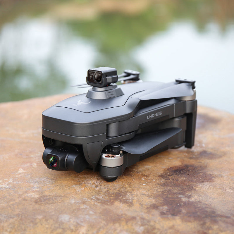 Black drone with camera on a wooden surface with a blurred natural background