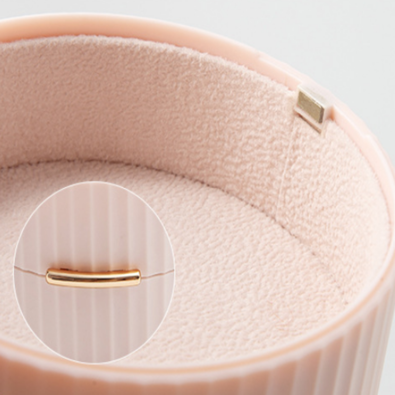 Close-up of a pink leather bracelet with a gold clasp on a light gray background