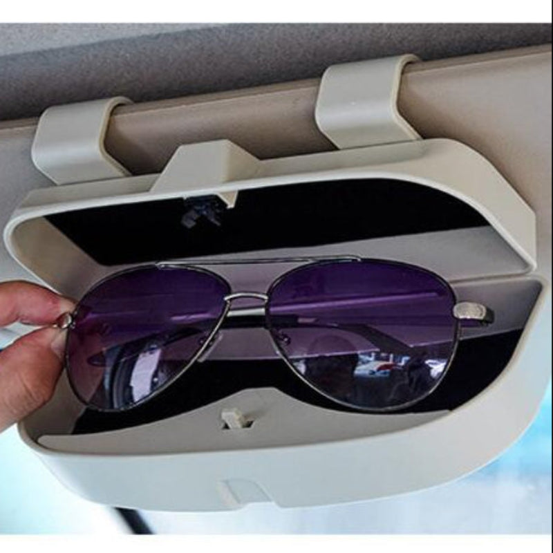 Car visor sunglasses holder with a hand placing sunglasses inside