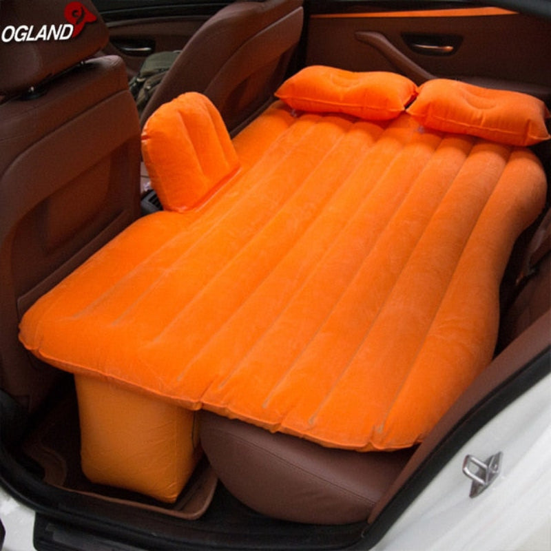 Orange inflatable mattress in a car trunk with OGLAND branding.