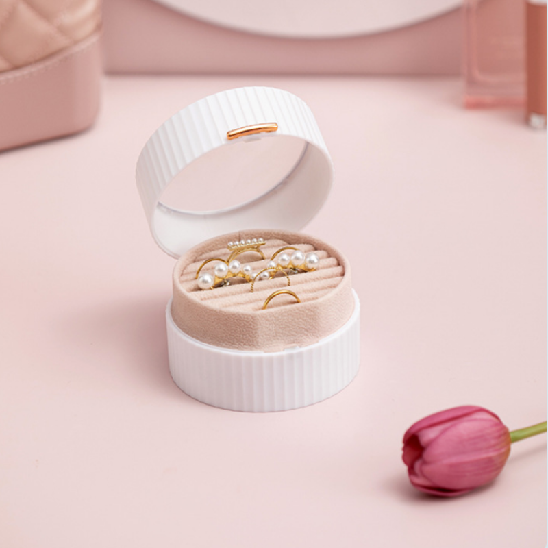 Open jewelry box with pearl earrings on a pink background