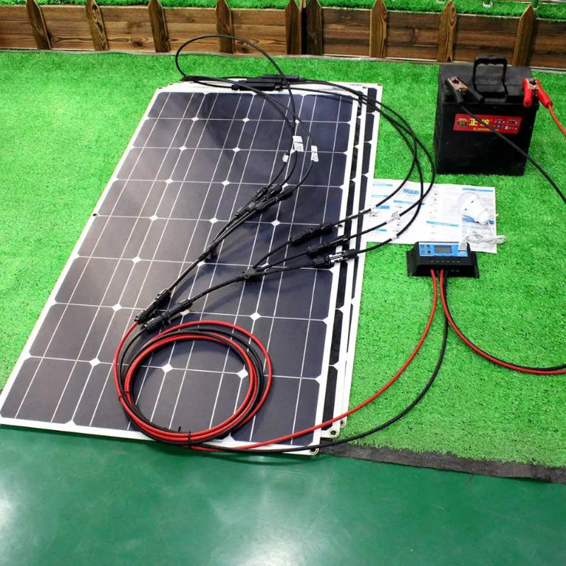 Solar panel with wiring and battery on a green surface