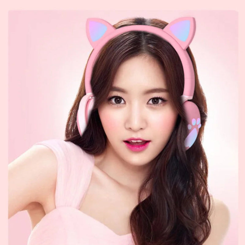 Pink cat ear headphones with LED lights on a pink background