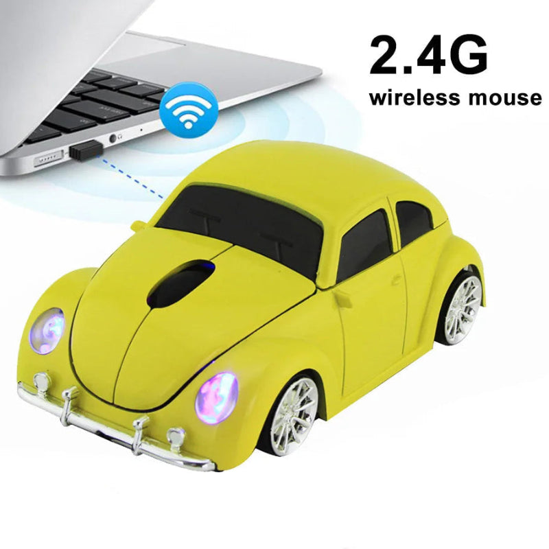 Yellow car-shaped wireless mouse with other colors and a laptop in the background.