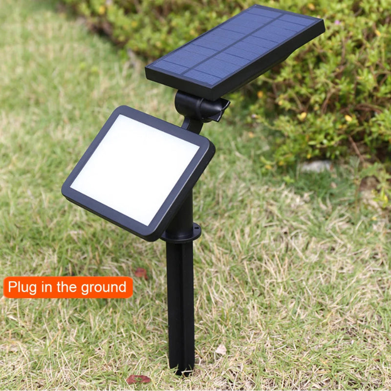 Solar-powered outdoor light fixture on grass with 'Plug in the ground' text.