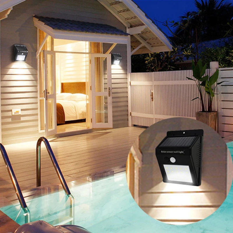 Solar-powered outdoor light fixture near a pool with a wooden cabin in the background.