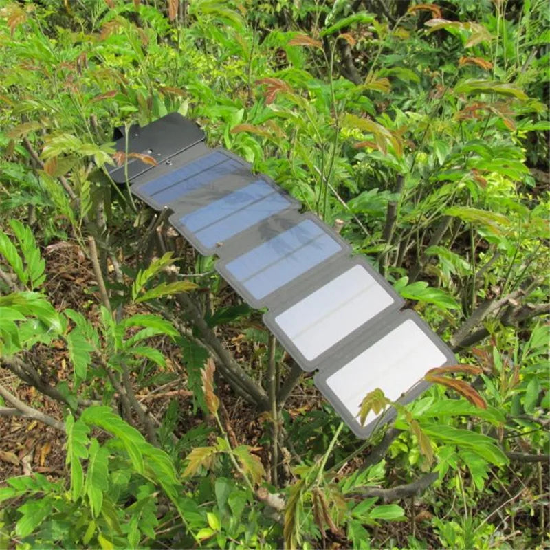 Foldable solar panel in a natural setting with greenery