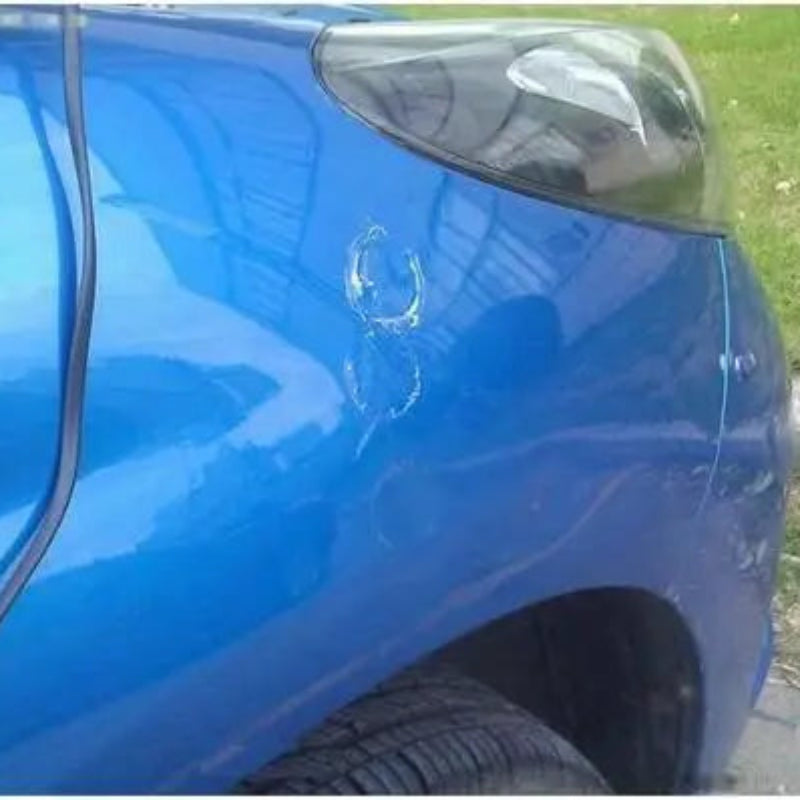 Blue car with a scratch on its side, parked outdoors.