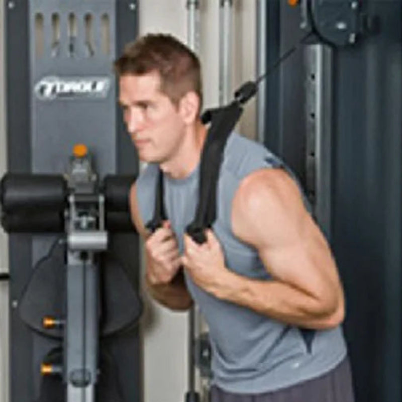 Man exercising on a cable machine in a gym setting