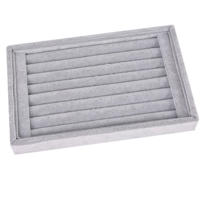 Gray jewelry tray with multiple compartments on a white background