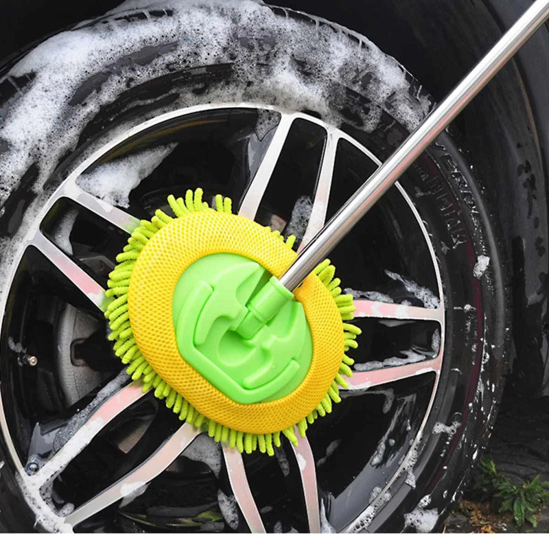 Green and yellow cleaning brush on a car wheel with soap suds