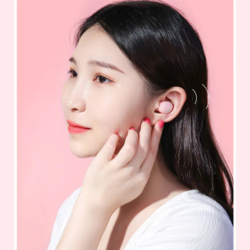 Woman with dark hair and white shirt against a pink background