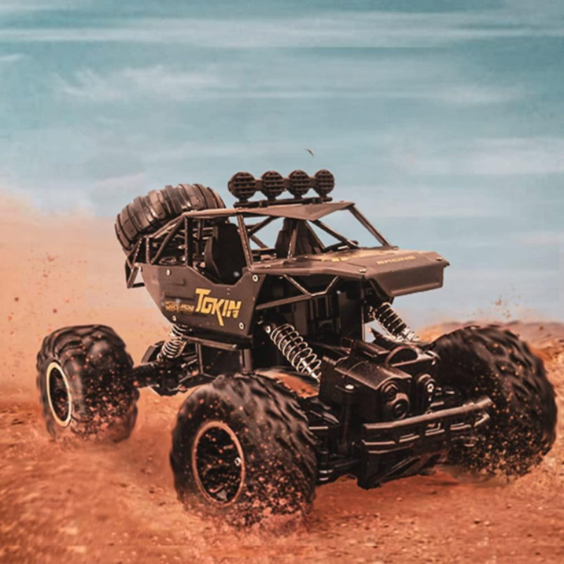 Toy monster truck with large wheels on a sandy surface