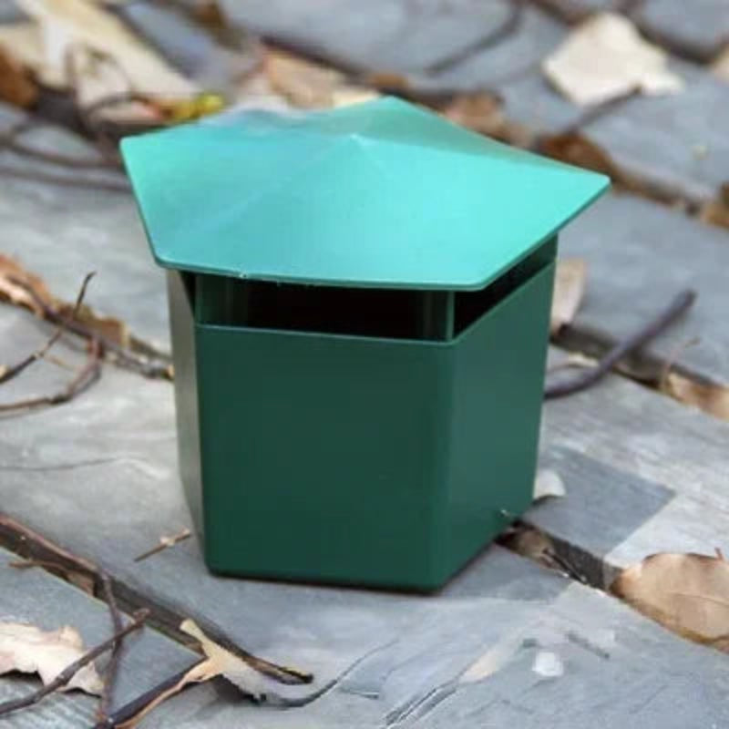Green metal vent on a roof with leaves and debris around