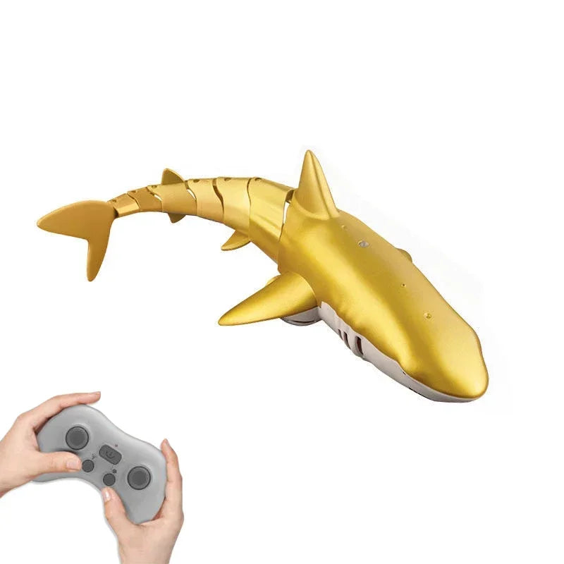 Gold shark-shaped remote control toy with a hand holding a controller on a white background