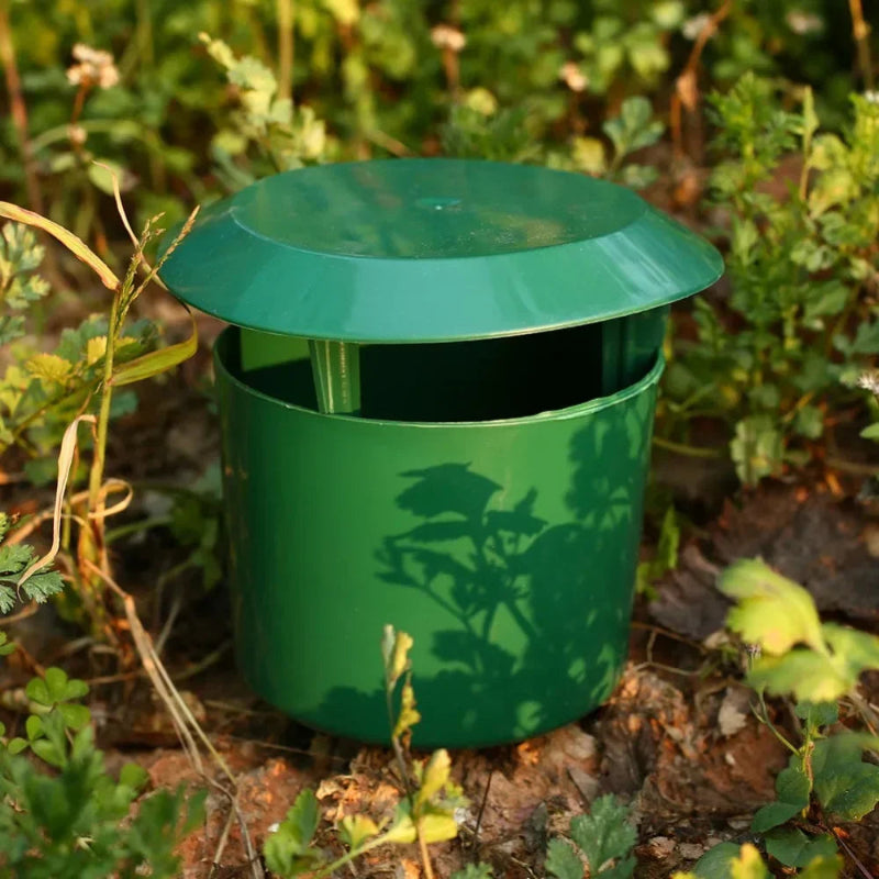 Green metal trash can in a garden setting