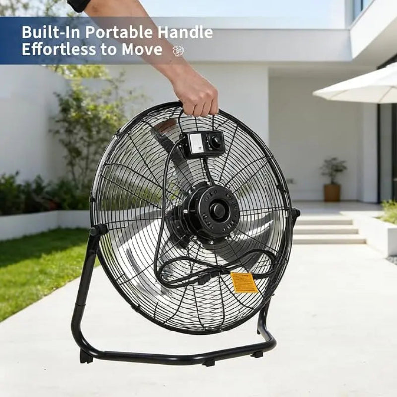 Black floor fan with a built-in portable handle in an outdoor setting.