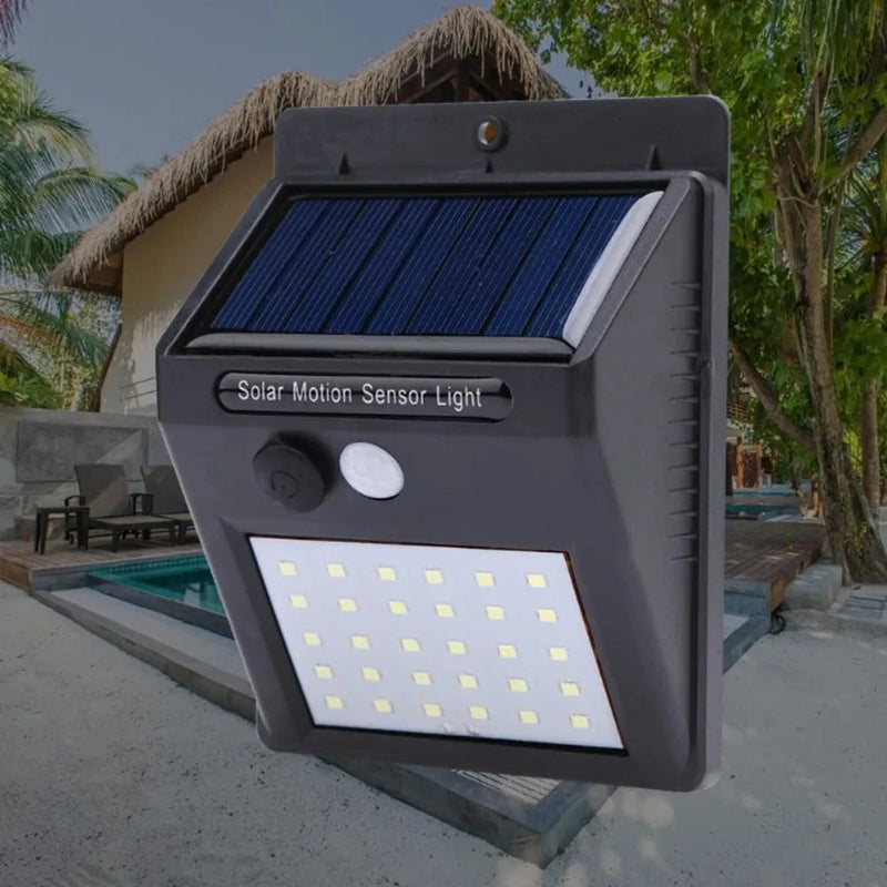 Solar motion sensor light on a wall with a tropical outdoor setting