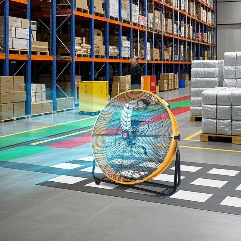 Large industrial fan in a warehouse setting with pallets and boxes in the background.