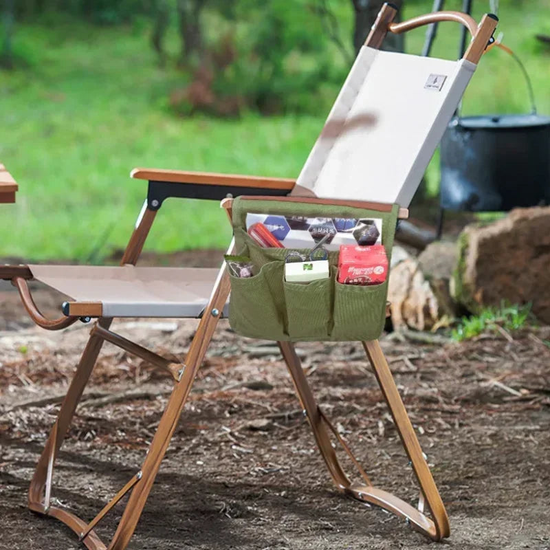 Foldable chair with a green storage bag attached, set outdoors on a natural background.