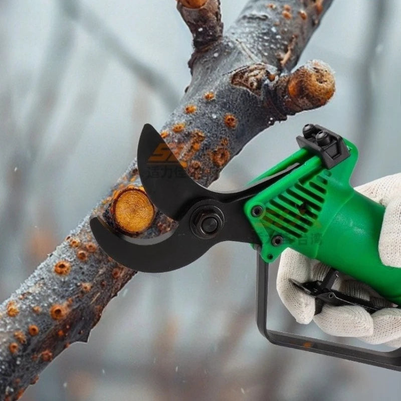 Green and black pruning shear cutting a branch with a blurred background
