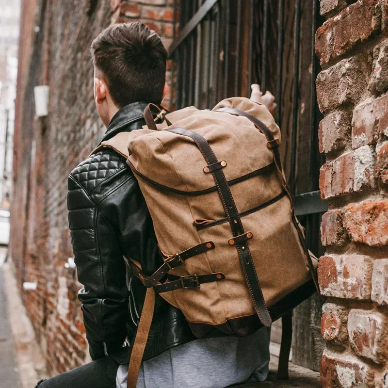 Person wearing a large brown backpack in an alleyway with brick walls.