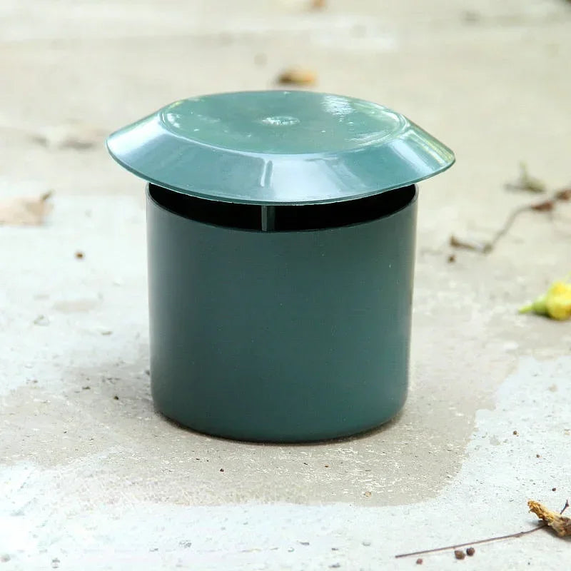 Green metal container with a lid on a sandy surface