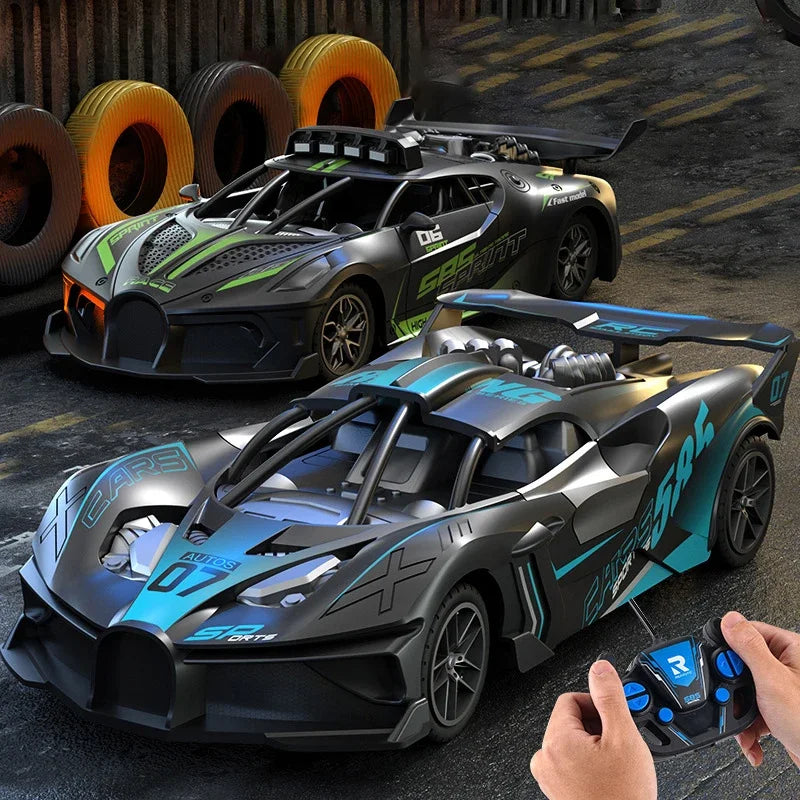 Two remote-controlled cars on a track with a hand holding a remote control.