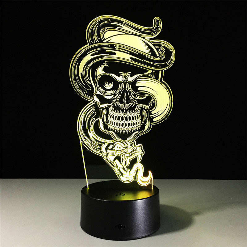 A 3D optical illusion LED night light featuring a glowing skull wearing a hat and smoking a cigar, mounted on a black cylindrical base against a dark background.
